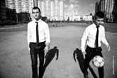 Фото двух мужчин моделей, идущих с футбольным мячом по полю