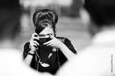 Черно-белое фото девушки модели с фотокамерой у лица
