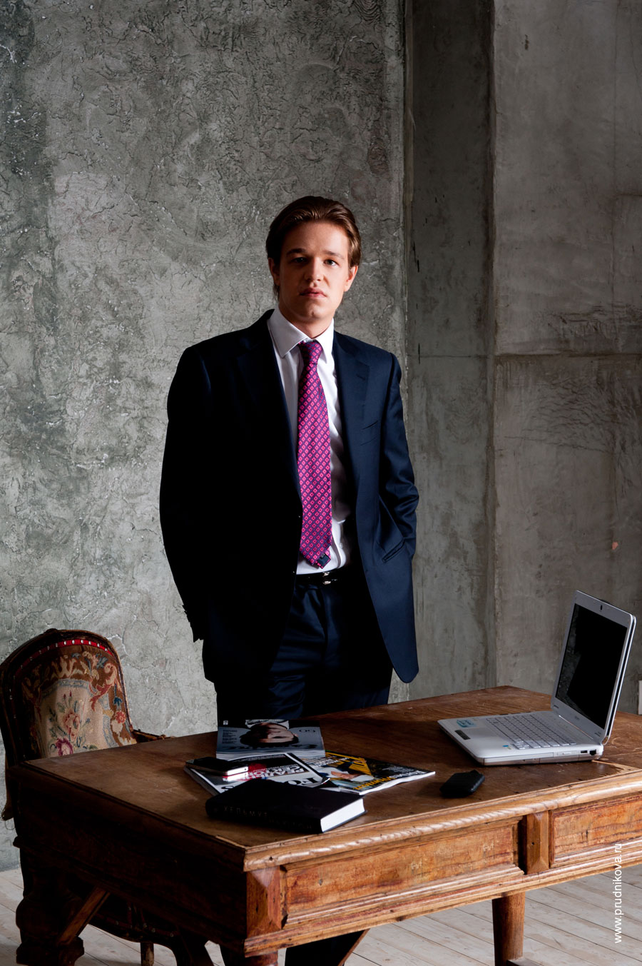 Фотопортрет делового мужчины в костюме за рабочим столом с ноутбуком