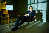 Фотография делового мужчины в костюме, сидя в кресле, в свете уличных ночных огней