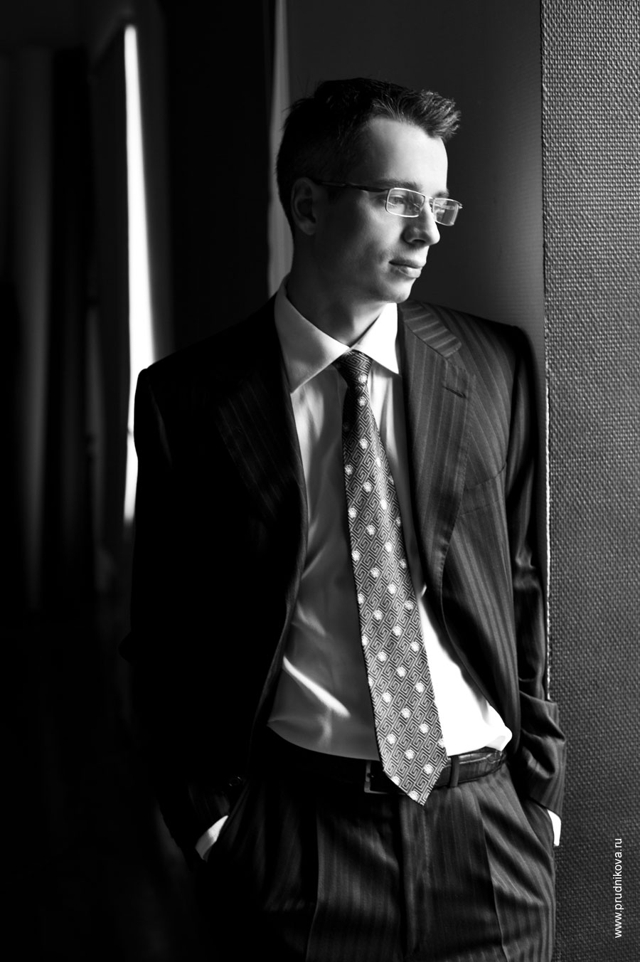 Поясное фото мужчины в очках в деловом костюме